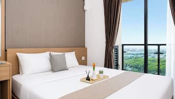 Una camera d'hotel con un letto grande, un comodino, una finestra con vista sulla città e una tenda.