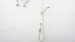 A bathroom with a shower and a faucet. - Cozy Well Located Studio Room At Apartment Sky House Bsd (Tangerang)