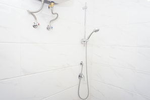 Ein Badezimmer mit Dusche und Wasserhahn.