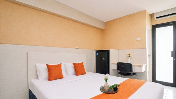 Una habitación de hotel con una cama, un escritorio y una silla.