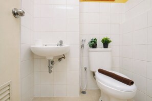 A bathroom with a white sink, toilet, and shower. - Warm And Efficient Studio At Apartment Kebagusan City (Jakarta)