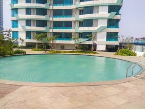 Ein modernes Gebäude mit Pool und umgebender Bepflanzung.