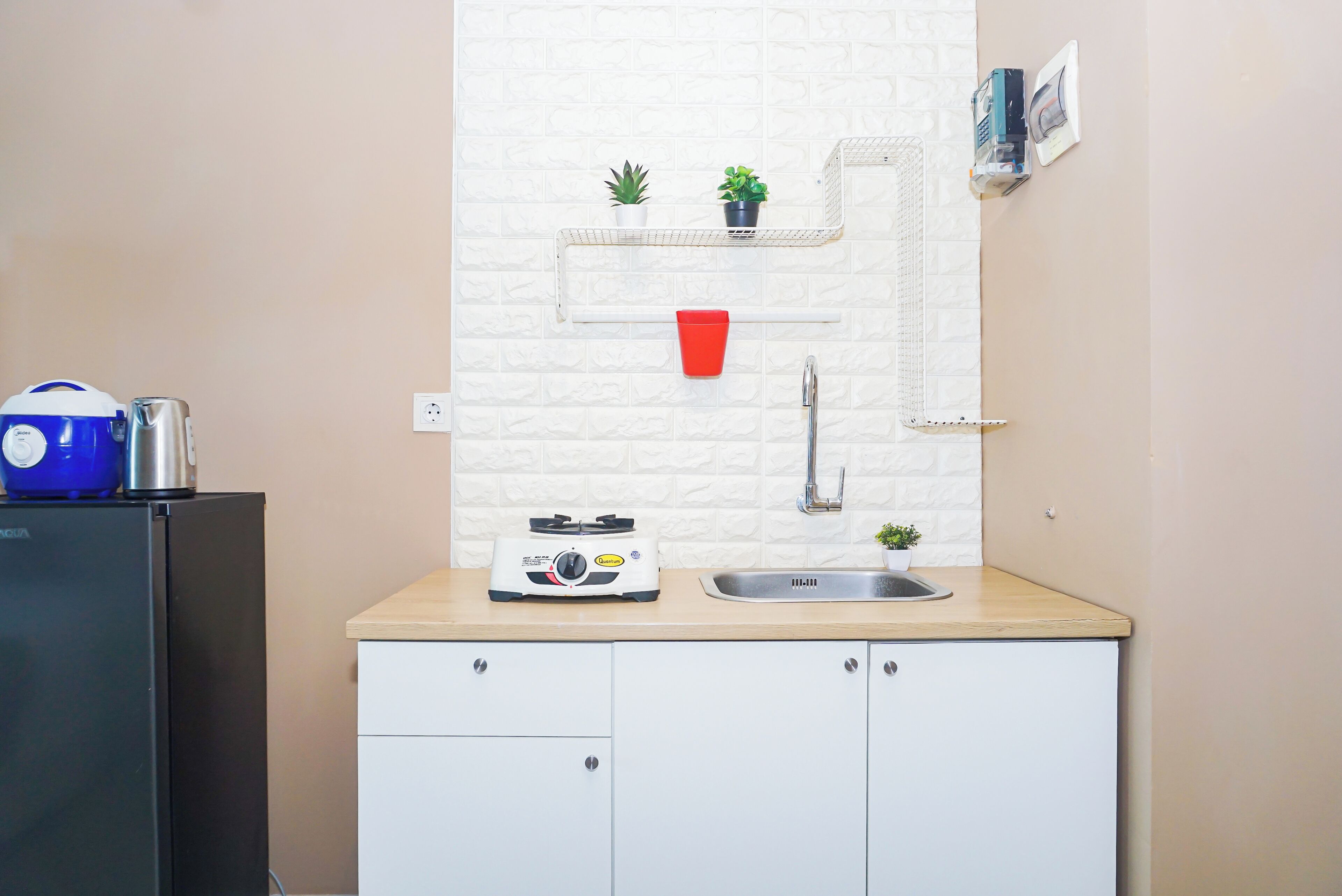Una cocina con mostrador, pileta, estufa y alacenas.