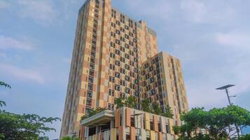 A multi-story building with a modern architectural design, featuring a mix of balconies and windows.