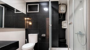A modern bathroom with a toilet, a bidet, a shower, and a glass-enclosed shower area. - Bright And Warm Combined 2Br At Apartment Suites @Metro (Bandung)