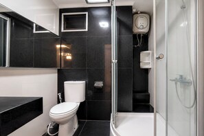 A modern bathroom with a toilet, a bidet, a shower, and a glass-enclosed shower area. - Bright And Warm Combined 2Br At Apartment Suites @Metro (Bandung)
