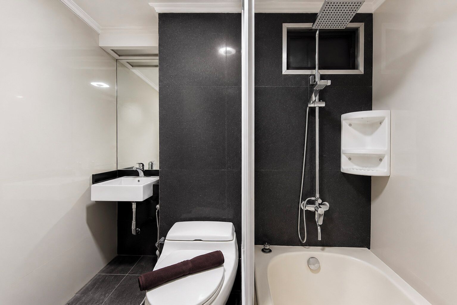 A modern bathroom with a toilet, sink, and bathtub.