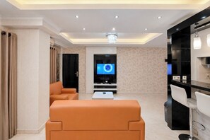 Ein modernes Wohnzimmer mit einer Couch, einem Flachbildfernseher und einem Couchtisch.
