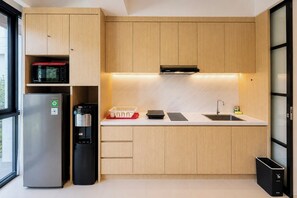 A modern kitchen with a built-in microwave, a coffee machine, a sink, and a trash bin. - Serene 1BR Lavaya Nusa Dua Bali (Bali)