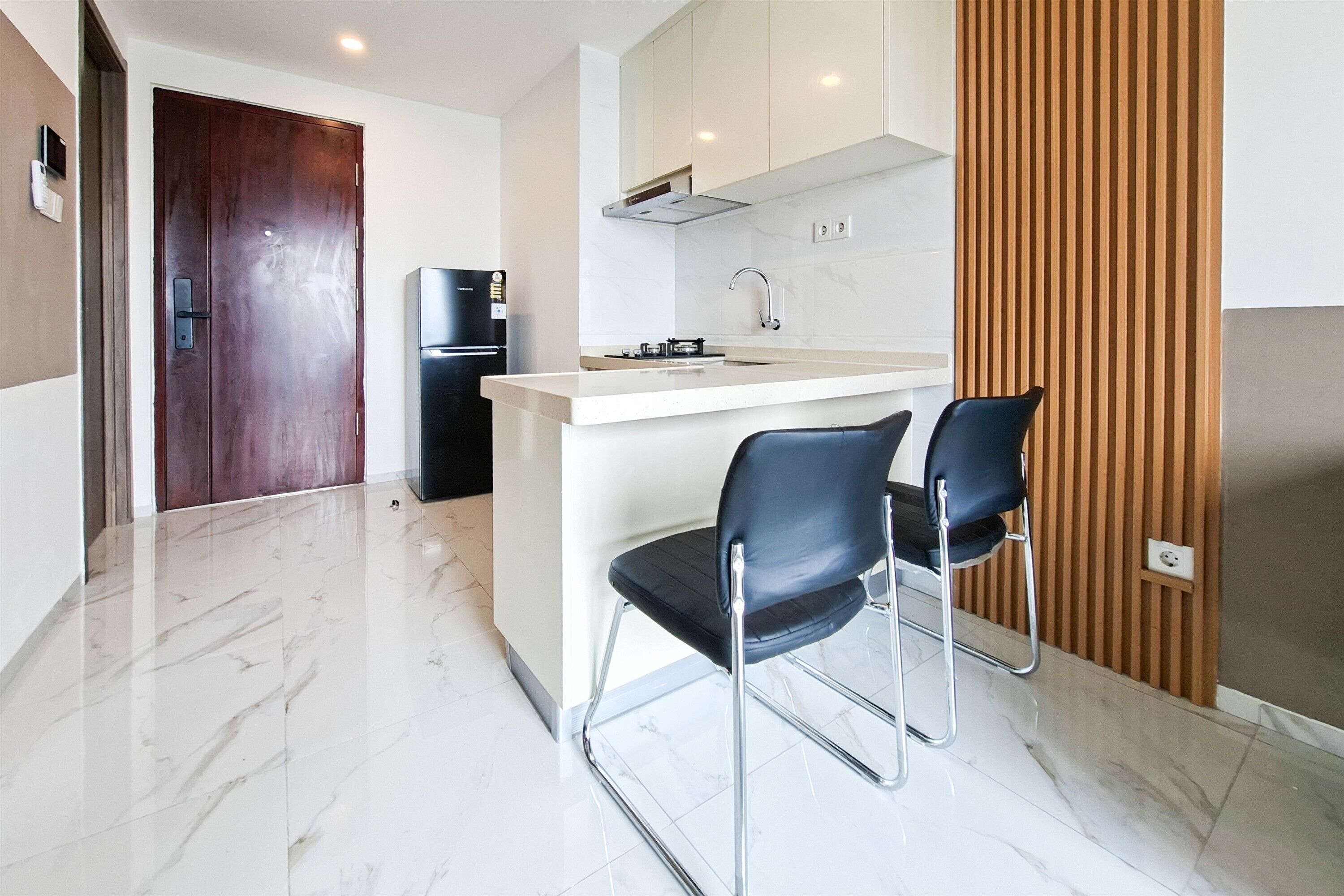 A modern kitchen with a built-in island, stainless steel appliances, and a wooden accent wall.