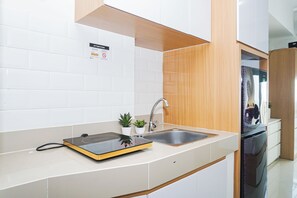 Eine moderne Küche mit eingebautem Herd, einer Spüle und einem Edelstahl-Kühlschrank.