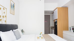 Quarto moderno com cama, mesa de cabeceira e vista para a cozinha.