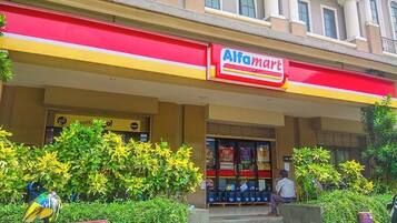 A building with a red and yellow awning labeled 'Alfamart'.