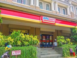 A building with a red and yellow awning labeled 'Alfamart'.