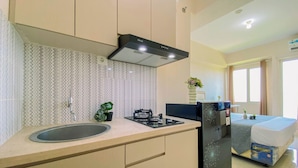 Una cocina compacta con un lavamanos, estufa y refrigerador.