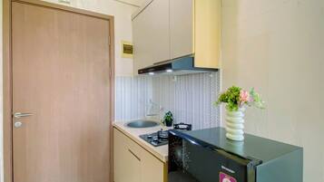 A compact kitchen with a gas stove, a sink, and a built-in oven.