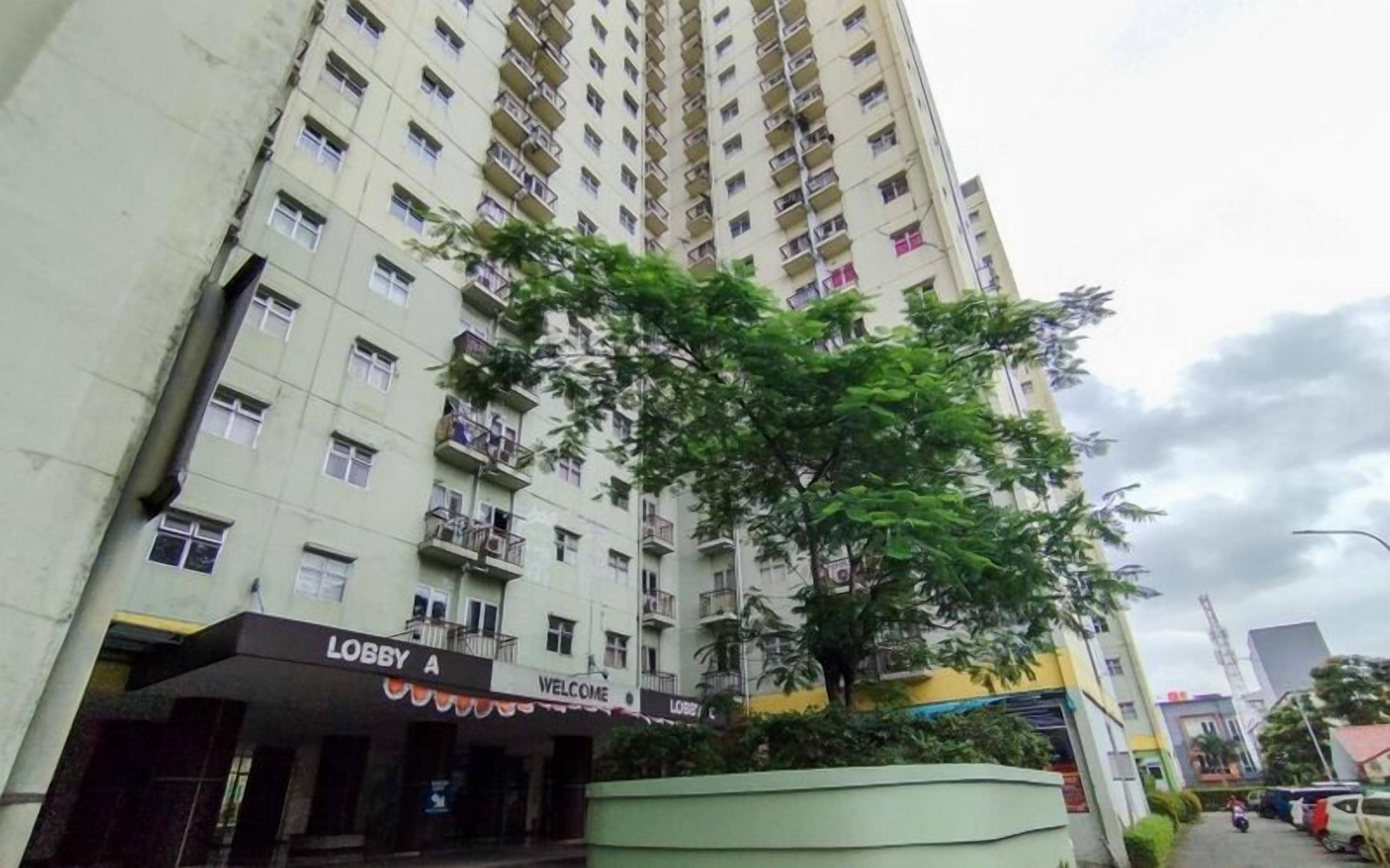 Un edificio de varios pisos con balcones y un letrero que dice 'Lobby A Welcome'.