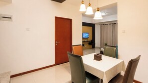 A dining area with a table, chairs, and pendant lights. - Homey 2Br (No Kitchen) At Apartment Marbella Suites Dago Pakar Bandung (Bandung)