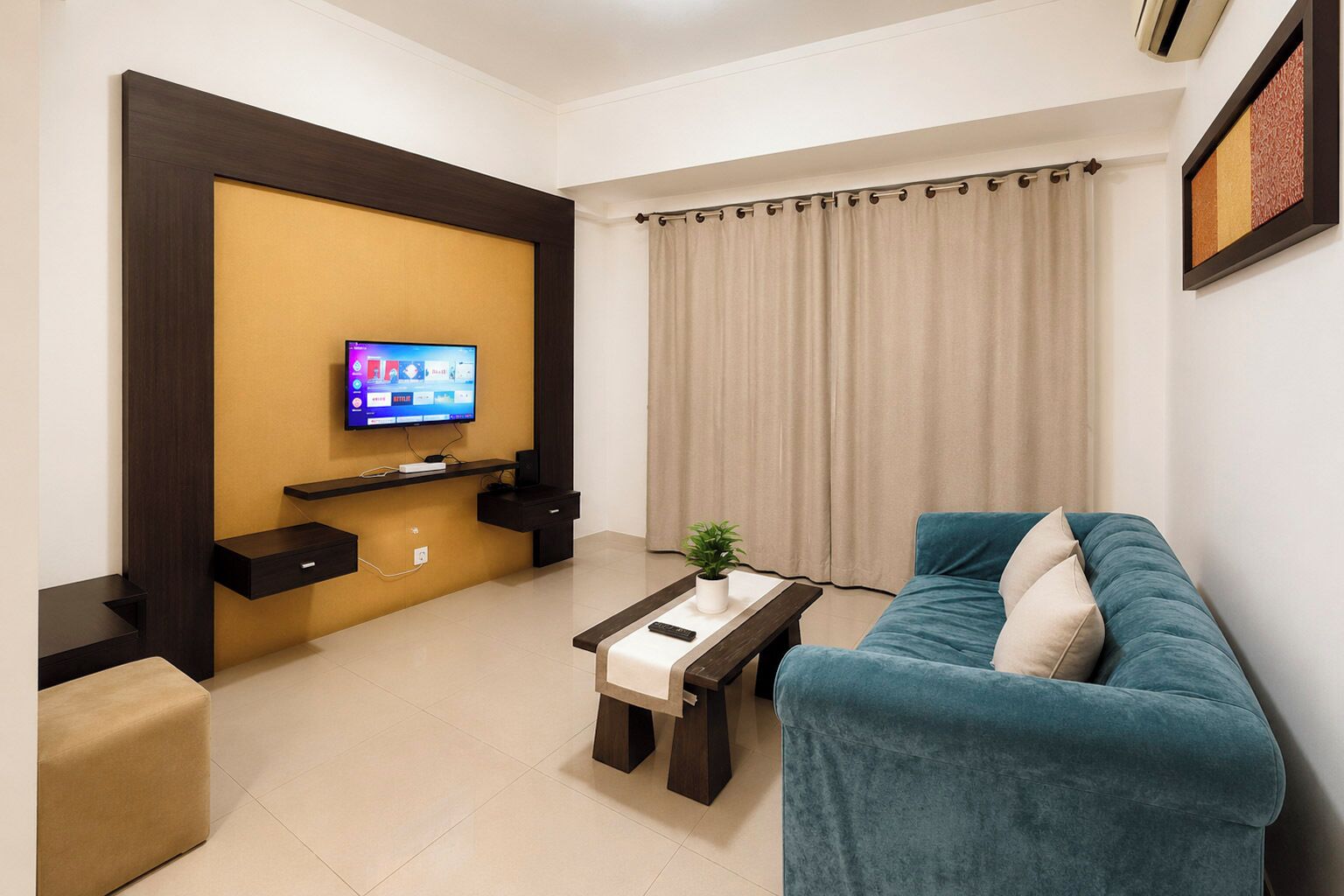 A living room with a TV, a sofa, a coffee table, and a plant.