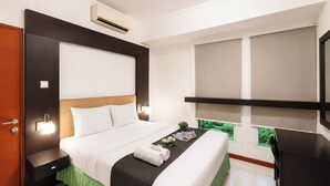 A hotel room with a bed, bedside tables, a desk, and a window with a view. - Homey 2Br (No Kitchen) At Apartment Marbella Suites Dago Pakar Bandung (Bandung)