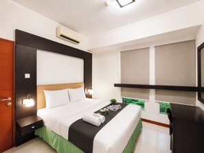 Ein Hotelzimmer mit einem Bett, Nachttischen, einem Schreibtisch und einem Fenster mit Blick.