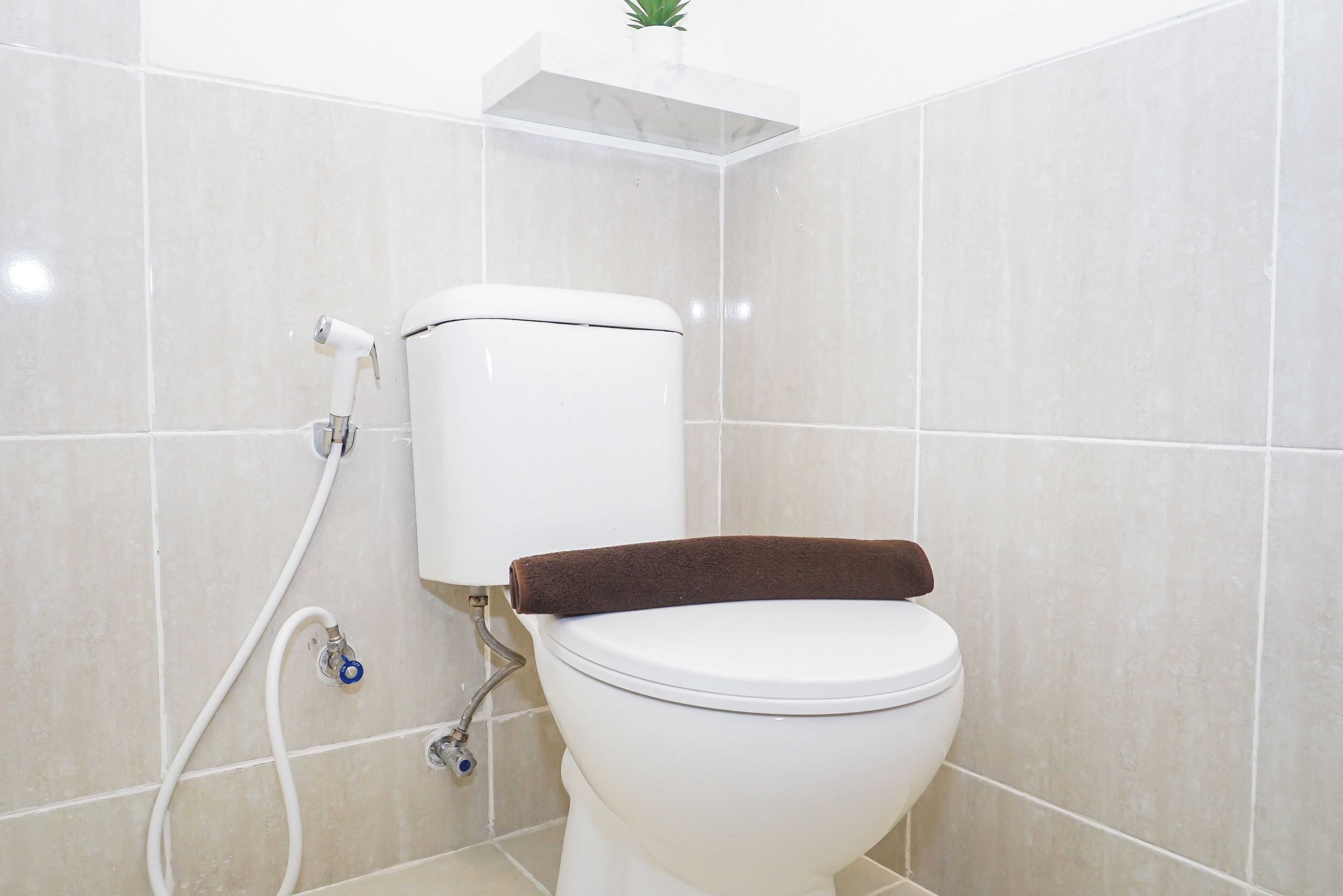 Un bagno con il water, una doccia e un porta asciugamani.
