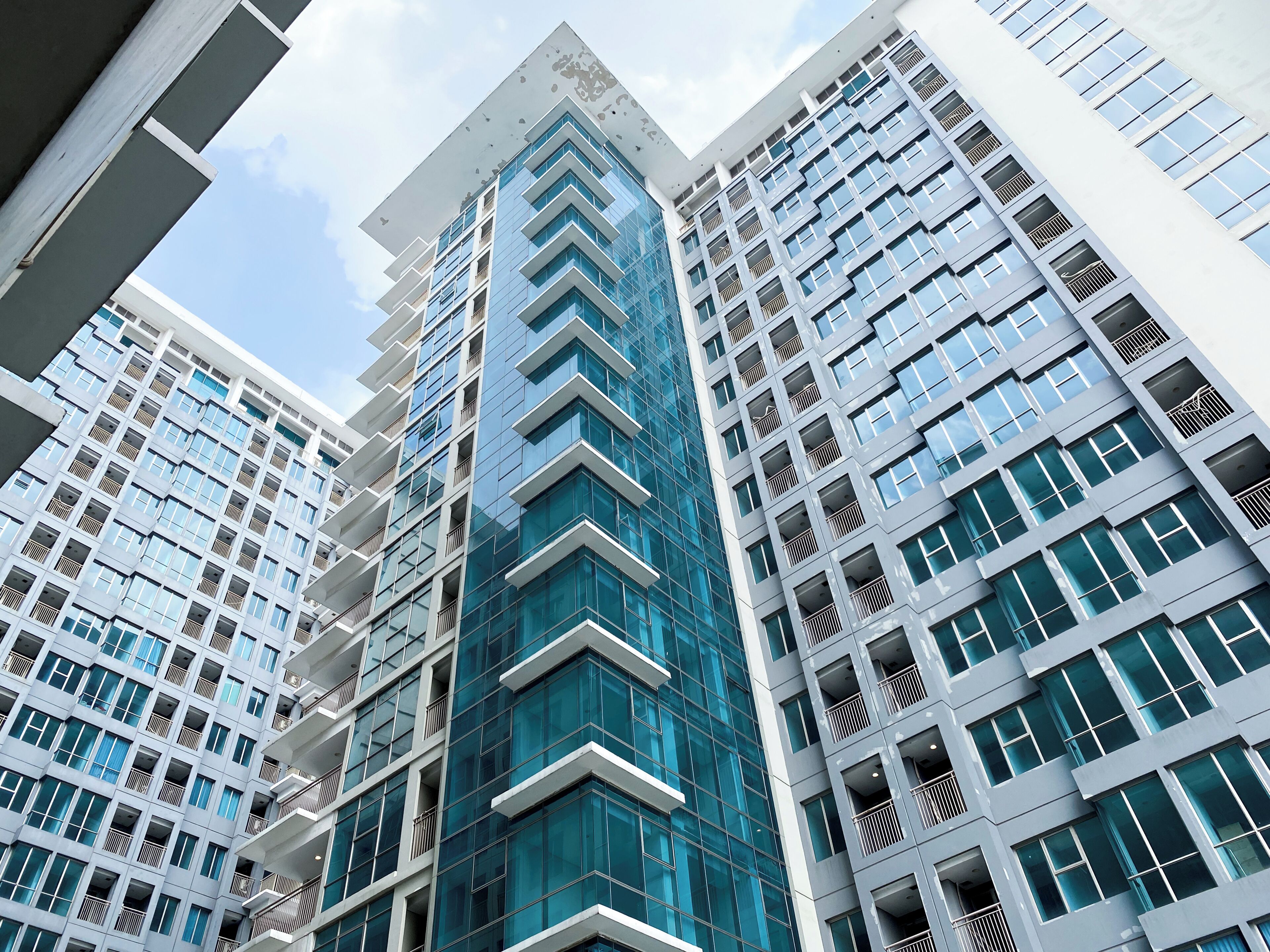 Un edificio moderno de rascacielos con varios pisos, ventanas amplias y balcones.
