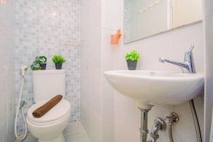A bathroom with a toilet, sink, and shower.