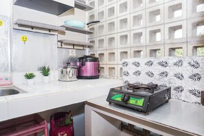 A kitchen with a gas stove, a pressure cooker, and a kettle. - Great Choice Studio Apartment At Margonda Residence 1 (Depok)