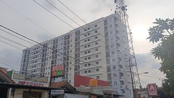Un edificio de varios pisos con balcones y una antena grande.