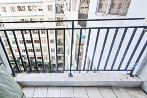 Un balcón con barandilla de metal que da a una zona residencial con varios edificios.