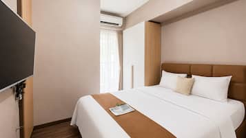 Et hotelværelse med seng, fladskærms-tv og aircondition.