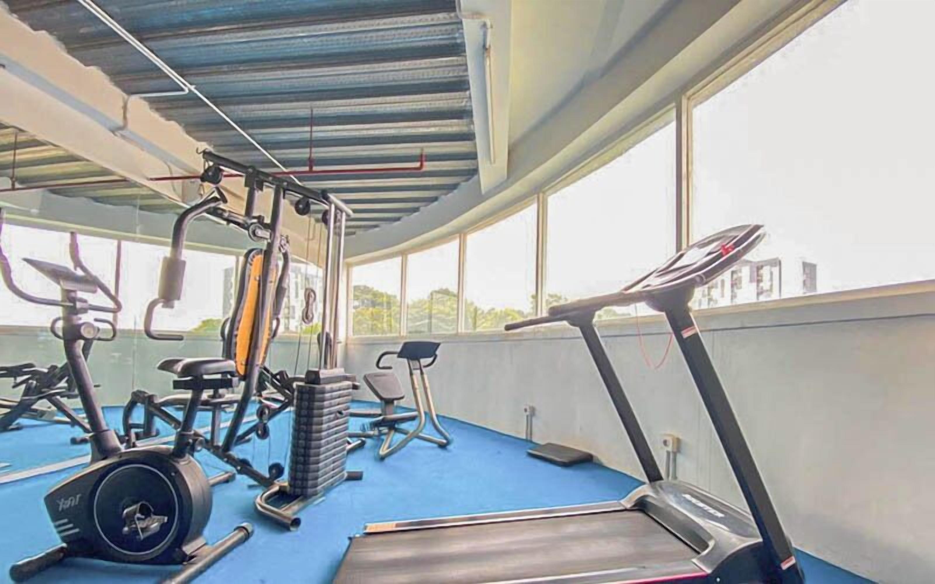 A gym with exercise equipment including treadmills, an elliptical, and weight machines.