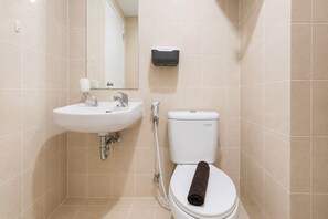 A bathroom with a white sink, a toilet, and a hand dryer. - Bright And Homey 2Br At Apartment Parahyangan Residence (Bandung)