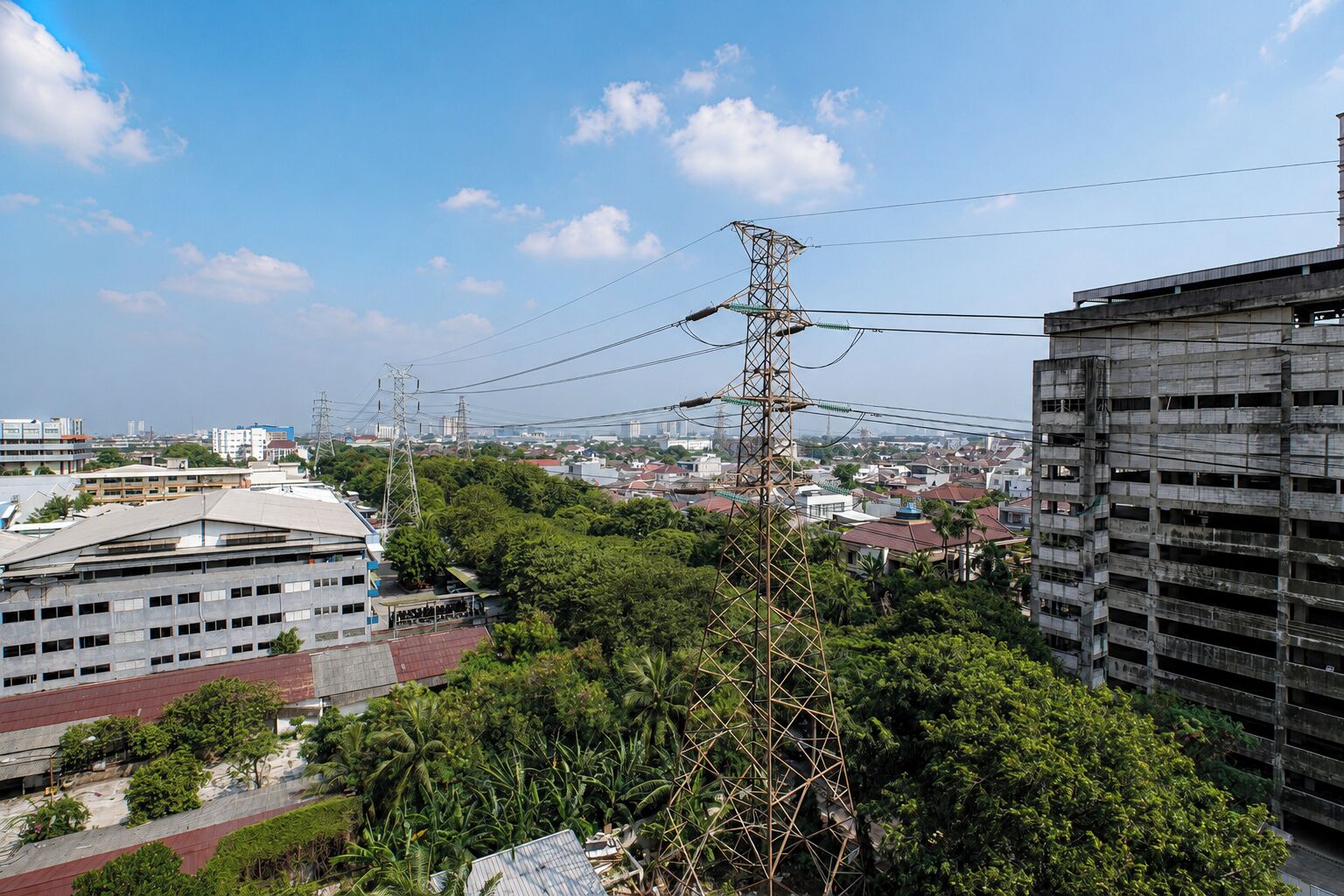 Ein Hochhaus mit mehreren Stockwerken, umgeben von Grünflächen und anderen Gebäuden.