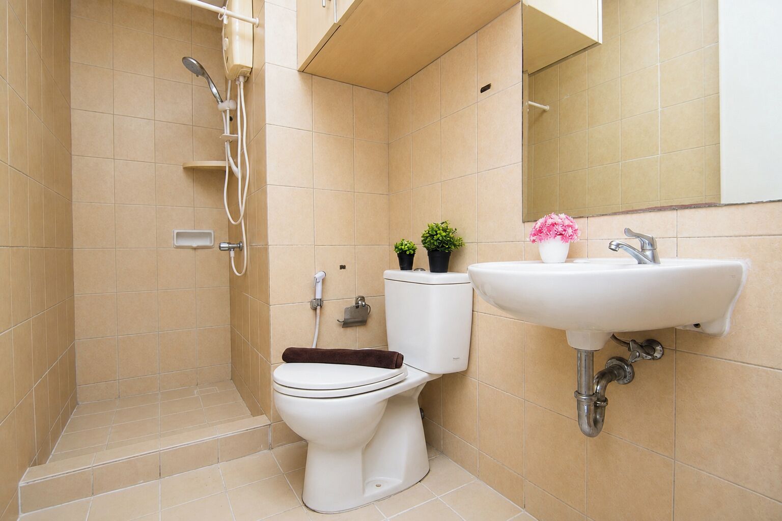A bathroom with a toilet, a shower, and a sink.