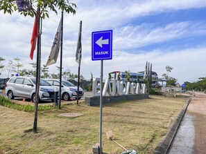 A parking area with cars and a blue directional sign indicating 'MASUK' (enter). - Good Minimalist Studio Room At Apartment Bandaraya - Tallasa City Makassar (Makassar (Ujung Pandang))