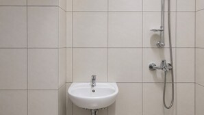 A bathroom with a white sink and a shower. - Good Minimalist Studio Room At Apartment Bandaraya - Tallasa City Makassar (Makassar (Ujung Pandang))