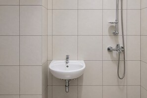 A bathroom with a white sink and a shower. - Good Minimalist Studio Room At Apartment Bandaraya - Tallasa City Makassar (Makassar (Ujung Pandang))