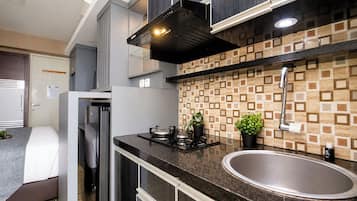 Una piccola cucina componibile con fornello a gas, lavello e mobili moderni.