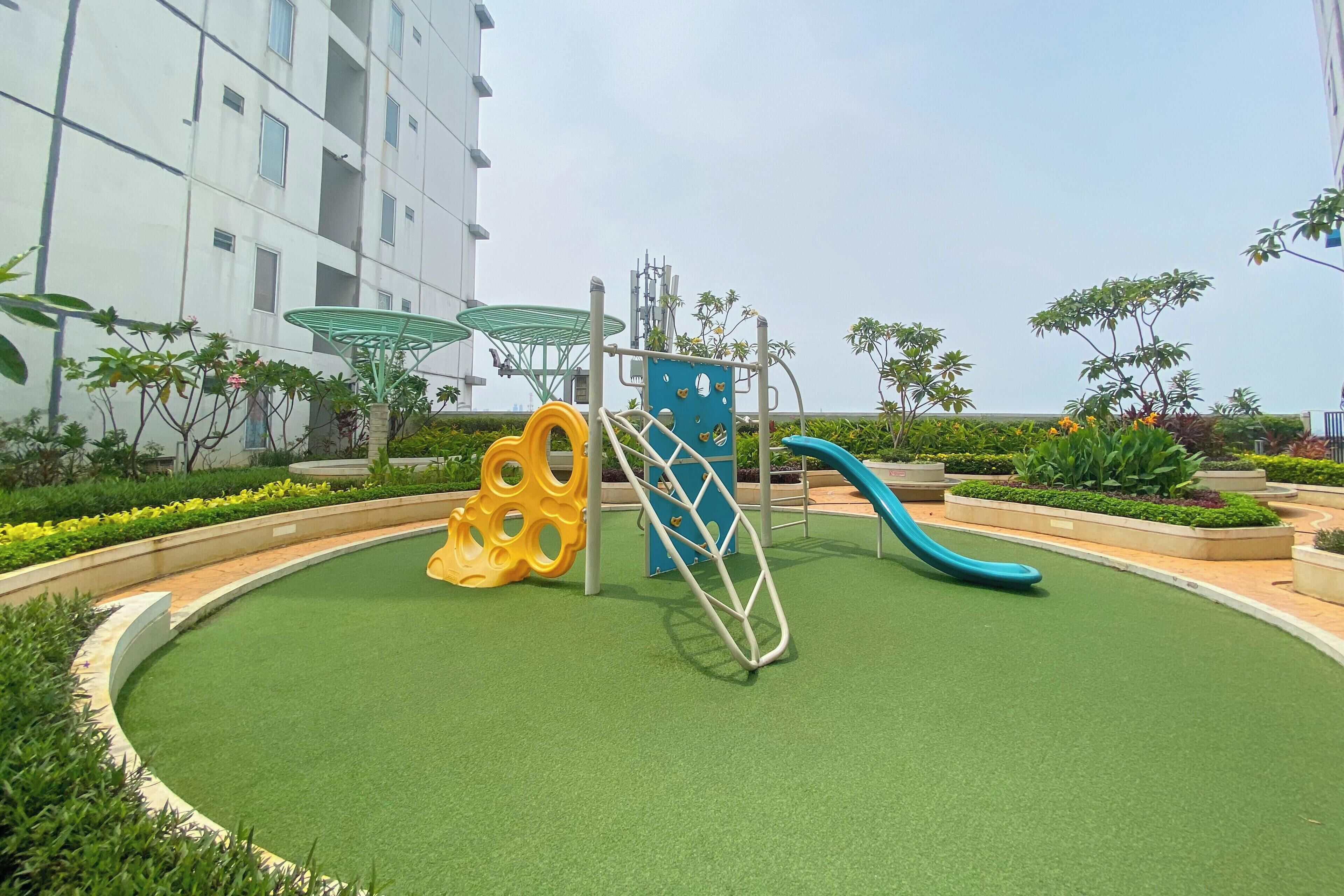 Un'area giochi con uno scivolo, una struttura di arrampicata e uno scivolo a spirale giallo.
