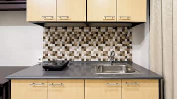 A kitchen with wooden cabinets, a tiled backsplash, and a stainless steel sink.