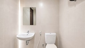 A bathroom with a white sink, toilet, and a mirror above the sink. - Urban Cozy Studio At Apartment Skyland City Jatinangor (Sumedang)