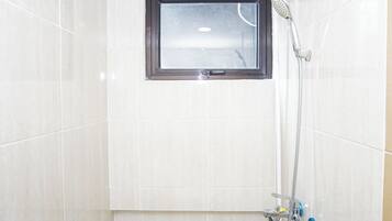Ducha con ventana, cabezal de ducha de mano y grifería empotrada.