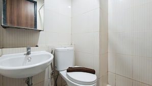 A bathroom with a white sink, toilet, and a towel rack. - Comfort Studio At Apartment Annora Living (Tangerang)