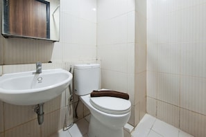 Ein Badezimmer mit einem weißen Waschbecken, einer Toilette und einem Handtuchhalter.