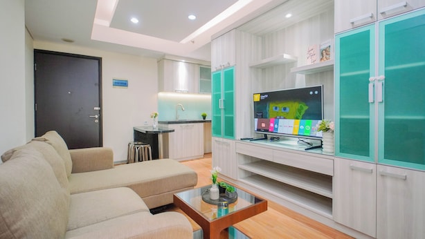 A modern living room with a sofa, a coffee table, and a TV on a stand. - Elegant & Cozy Living 2Br Boutique Kemayoran Apartment Next To Citra Xperience Mall (Jakarta)