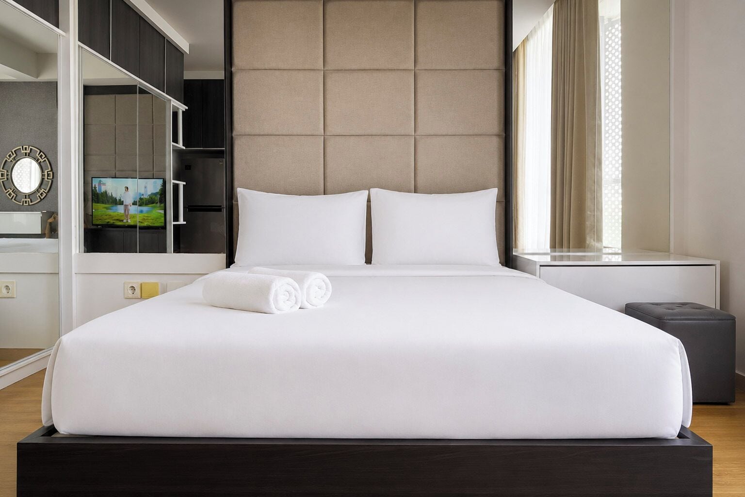 Habitación de hotel con una cama grande, televisión, armario y mesita de noche.