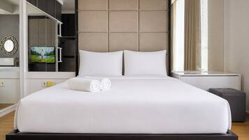 Habitación de hotel con una cama grande, televisión, armario y mesita de noche.