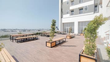 A rooftop terrace with outdoor seating and potted plants.